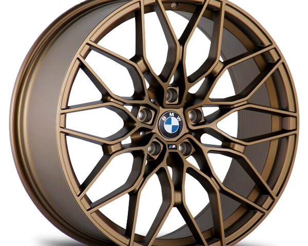 A bronze alloy car wheel rim with an intricate spoke design featuring the BMW logo at the center, displayed against a plain white background.
