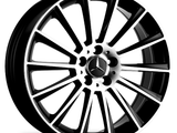 A black and silver car wheel rim features a star emblem in the center and 