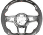 A steering wheel with an exposed interior structure, featuring carbon fiber details and a digital display at the top. The wheel is set against a plain white background.