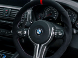 Steering wheel features a BMW logo, carbon fiber accents, and control buttons. The dashboard includes speedometers and a navigation screen, set within a modern car interior on a rainy day.