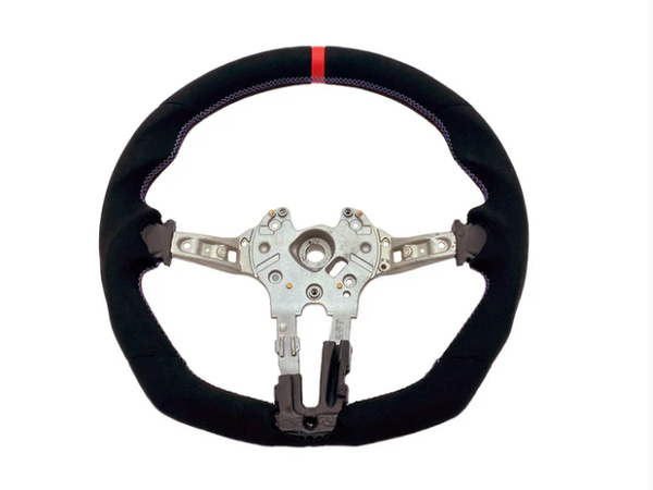 A steering wheel with a black, fabric-covered rim and a red stripe at the top, features a metallic core with attachment points, against a plain white background.