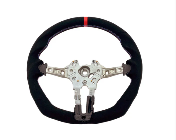 A steering wheel with a black, fabric-covered rim and a red stripe at the top, features a metallic core with attachment points, against a plain white background.