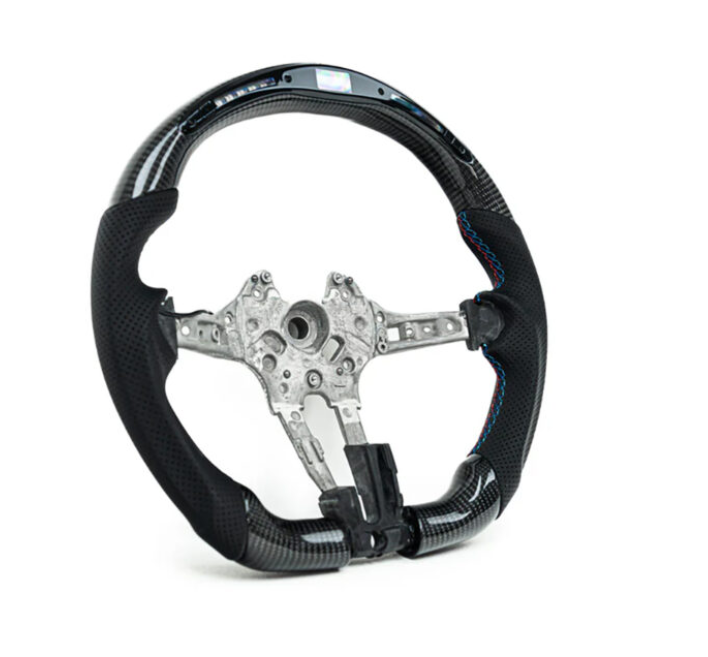 A black carbon fiber steering wheel with a metal frame is displayed against a white background. Blue stitching accents the grip areas, highlighting the sleek, sporty design.