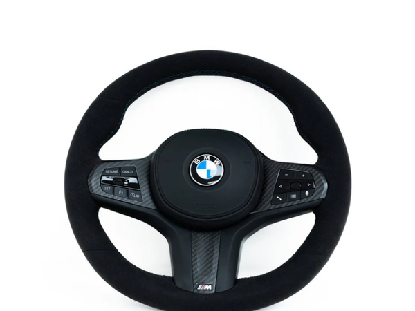A round, black BMW steering wheel, featuring control buttons, is set against a plain white background. BMW logo in the center, "M" branding below.