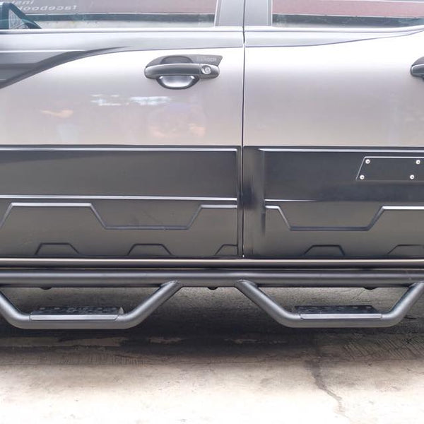 A rugged vehicle features side protective bars and reinforced step plates along two tightly sealed, dark-colored doors, parked on a concrete surface with large off-road tires partially visible.