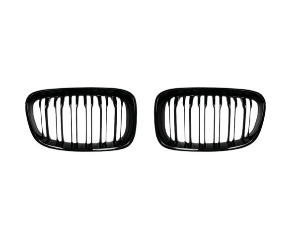 Two black, oval-shaped car grilles with vertical slats sit side by side against a plain white background, suggesting automotive components for vehicle front ends.