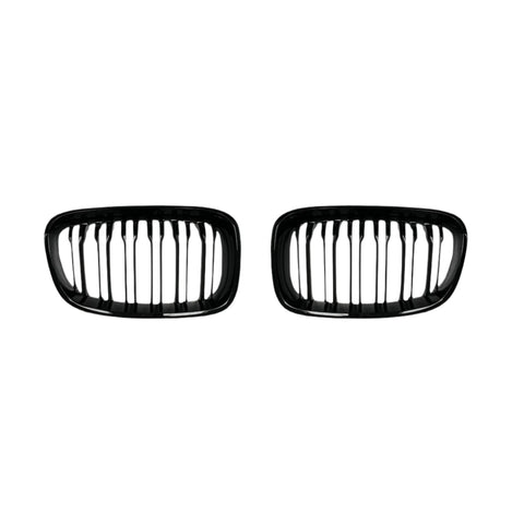 Two black, oval-shaped car grilles with vertical slats sit side by side against a plain white background, suggesting automotive components for vehicle front ends.