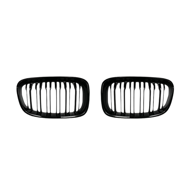 Two black, oval-shaped car grilles with vertical slats sit side by side against a plain white background, suggesting automotive components for vehicle front ends.