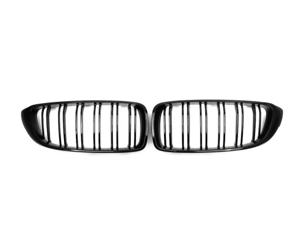 Two black, modular car grilles featuring vertical slats lie side by side against a plain white background.