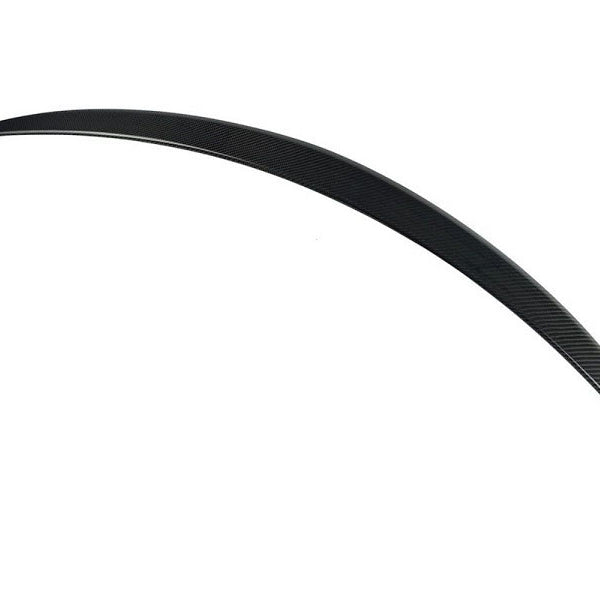 A curved carbon fiber surfboard fin, sleek and streamlined, appears against a plain white background, highlighting its thin, aerodynamic design.