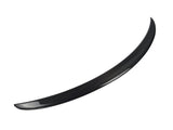 A curved, black carbon fiber car spoiler is displayed, isolated against a plain white background, emphasizing its smooth, aerodynamic design.