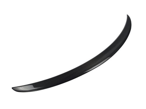 A curved, black carbon fiber car spoiler is displayed, isolated against a plain white background, emphasizing its smooth, aerodynamic design.