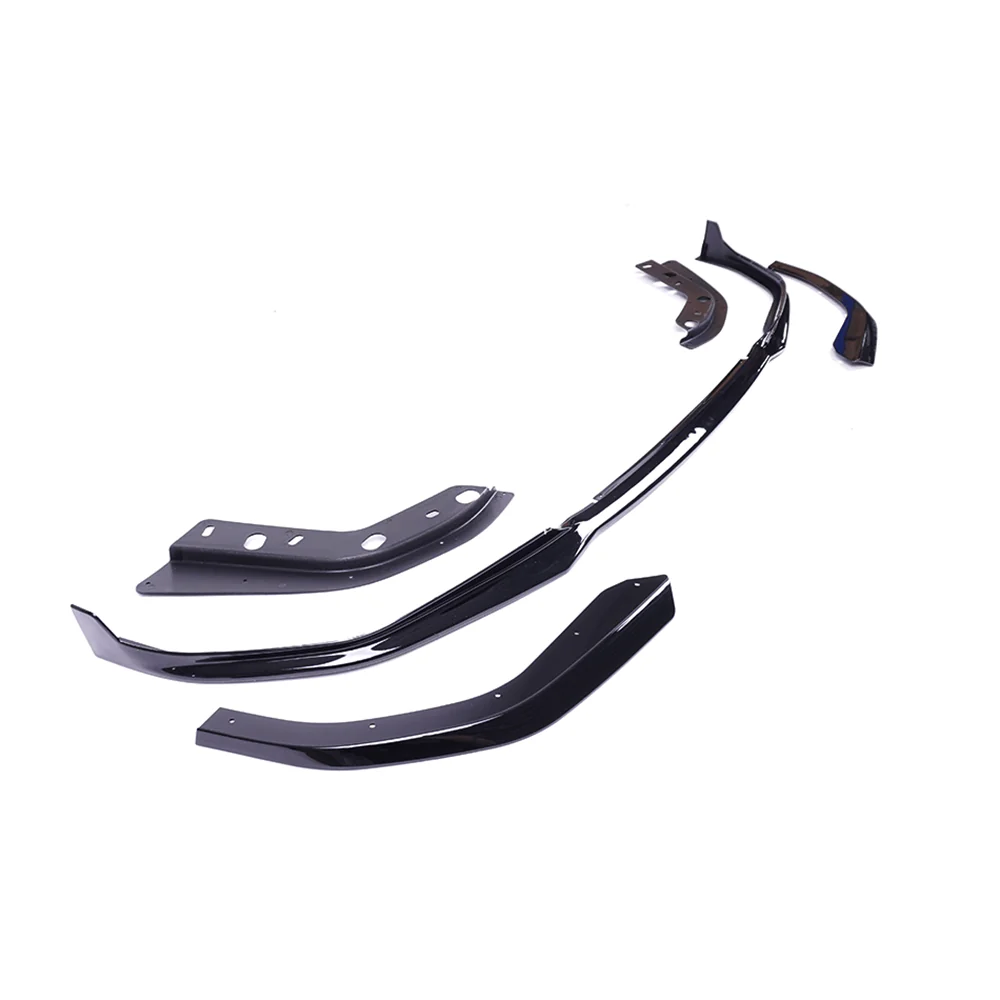 Several glossy black car body kit components are arranged on a white background, showing various angles and ridges, suggesting customization parts for vehicle exterior modification.