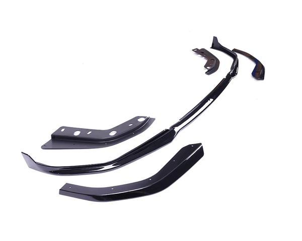 Several glossy black car body kit components are arranged on a white background, showing various angles and ridges, suggesting customization parts for vehicle exterior modification.