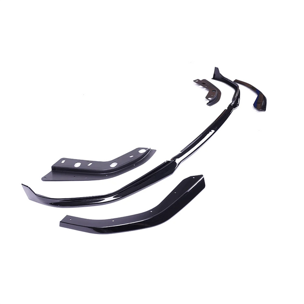 Several glossy black car body kit components are arranged on a white background, showing various angles and ridges, suggesting customization parts for vehicle exterior modification.