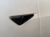 Carbon fiber triangular vent, embedded in a smooth white surface, showcasing contrasting textures on what appears to be a vehicle body exterior.