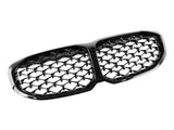 A shiny black dual-section car grille, featuring a diamond pattern, is set against a plain white background, emphasizing its sleek and glossy design.