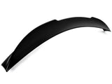 A black, curved car spoiler rests on a plain white background, displaying its smooth, aerodynamic design intended for vehicle performance enhancement. No text present.