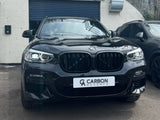 A black BMW parked in front of a garage, displaying a 