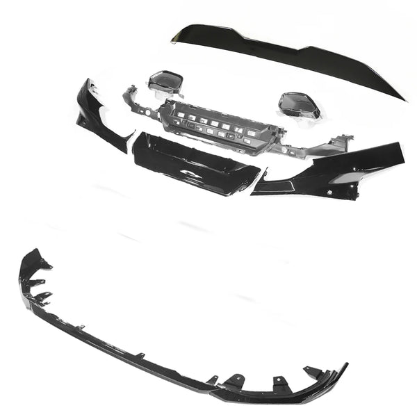 Car bumper kit with various black components, including a grille and trim pieces, spread out on a white background.