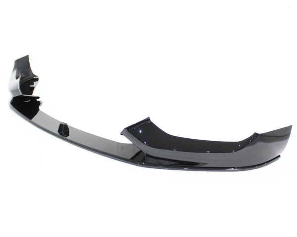 A glossy black car front bumper lip sits on a plain white background, featuring a sleek, aerodynamic design with curved edges and mounting points.