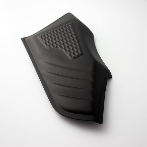 A black, textured rubber pad with diagonal grooves and a grid pattern, lays on a flat, white background.