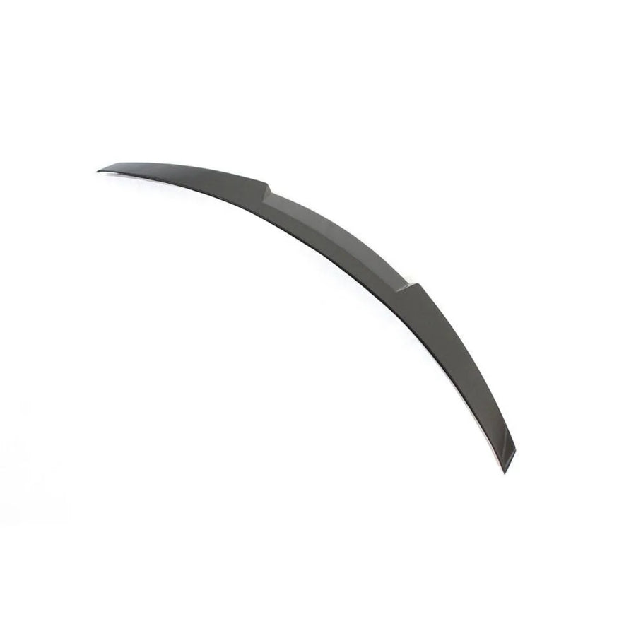 A curved, dark-colored blade-like object lies flat on a plain white background. It features a smooth surface with slightly angled edges, suggesting a sleek, aerodynamic design.