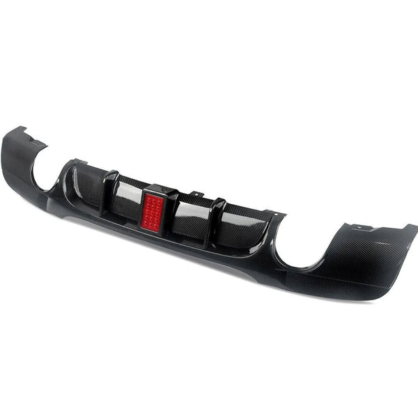 A carbon fiber car diffuser with a central red LED light is positioned on a white background, designed to improve aerodynamics and add visual appeal to the vehicle's rear.