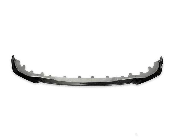 A curved car front splitter sits isolated against a plain white background, featuring a black aerodynamic design and notches along its length, suggesting attachment points.