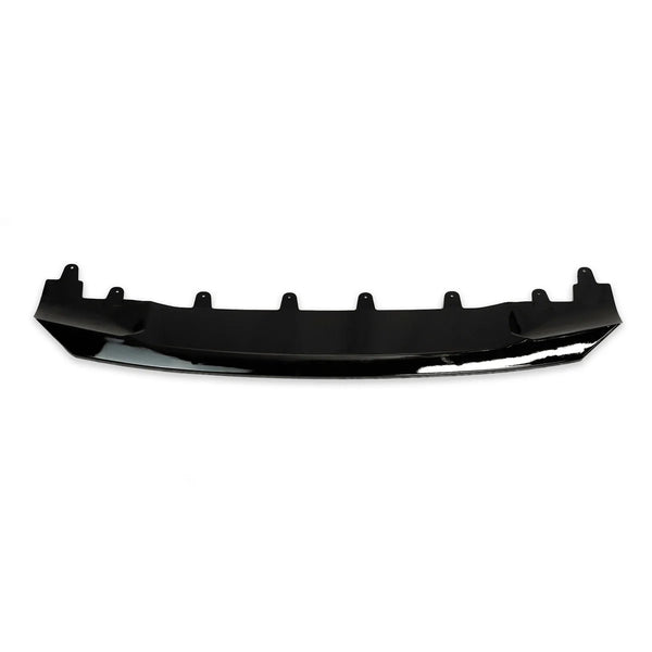 A black car bumper lip lies horizontally, with multiple mounting tabs along its top edge, set against a plain white background.