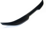 A glossy black car spoiler sits isolated against a plain white background. Its sleek, curved design features angular edges, suggesting it is an aerodynamic component for a vehicle's rear.
