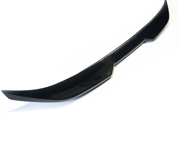 A glossy black car spoiler sits isolated against a plain white background. Its sleek, curved design features angular edges, suggesting it is an aerodynamic component for a vehicle's rear.