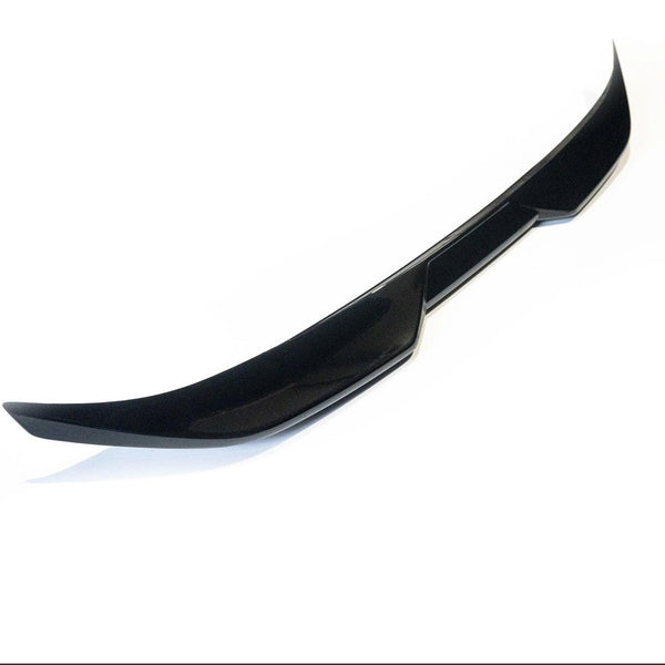 A glossy black car spoiler sits isolated against a plain white background. Its sleek, curved design features angular edges, suggesting it is an aerodynamic component for a vehicle's rear.