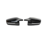 Two sleek black car side mirrors are positioned facing each other against a plain white background, emphasizing their glossy finish and aerodynamic design.