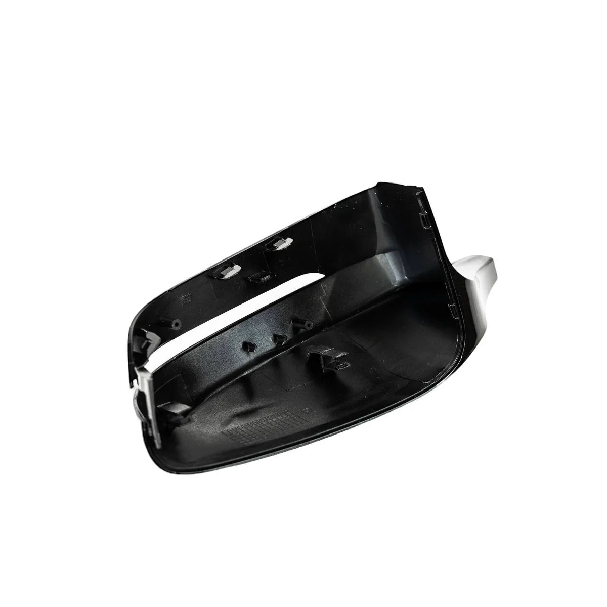 A black plastic car side mirror cover is angled, exposing interior clips and attachment points, against a plain white background.