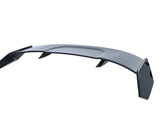A sleek, curved car spoiler with angular edges and two side supports is displayed against a plain white background, emphasizing its aerodynamic design.