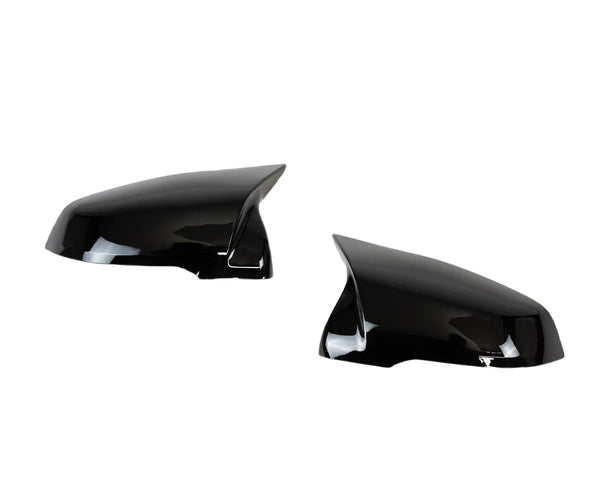Two glossy black side mirror covers are displayed against a plain white background, angled toward each other, reflecting light on their smooth surfaces.
