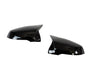 Two shiny black side mirror covers are positioned facing each other against a white background, highlighting their sleek, aerodynamic design.