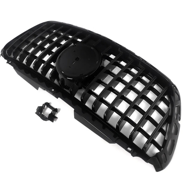 A black car grille with a mesh design lies on a white background. It features a central circular mount for an emblem, accompanied by an additional small attachment piece nearby.