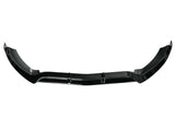 A black car front splitter with aerodynamic contours lies on a white background, emphasizing its sleek, angular design intended to reduce air resistance and enhance vehicle performance.