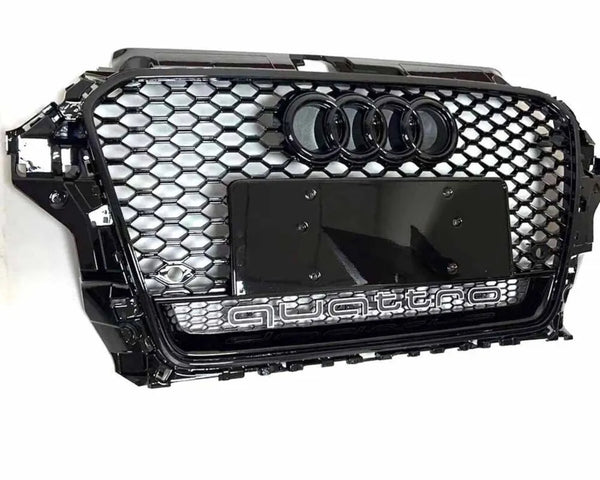 A hexagonal black car grille features four interlocking rings above a blank license plate holder. "quattro" is inscribed beneath, highlighting a sleek automotive design against a plain white background.