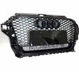 A hexagonal black car grille features four interlocking rings above a blank license plate holder. "quattro" is inscribed beneath, highlighting a sleek automotive design against a plain white background.