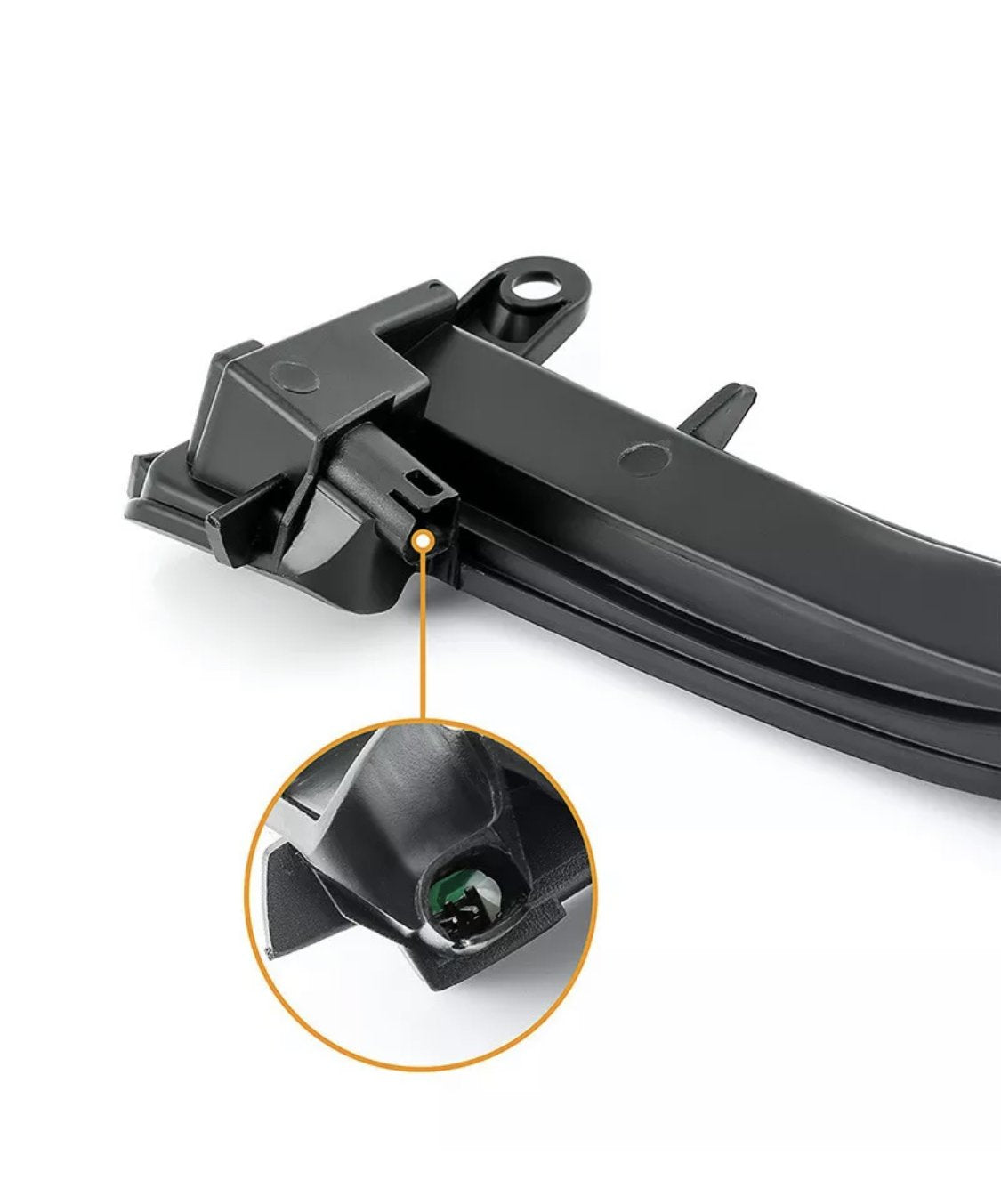 A black plastic car part positioned against a white background, with a magnified circle highlighting a small green component inside it.