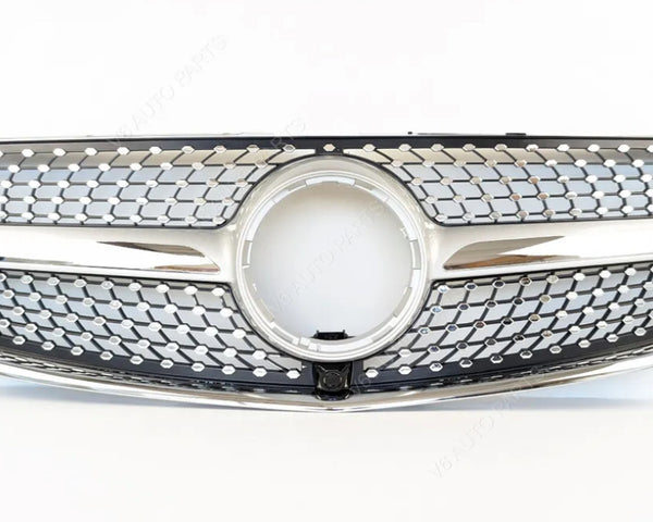 A shiny car grille features a prominent circular center, intricate mesh pattern, and chrome accents, positioned against a plain white background.