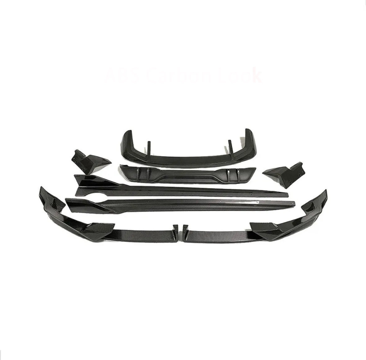 Car body kit parts arranged on a white background, featuring multiple angular black pieces designed for aerodynamic enhancement. Text reads "ABS Carbon Look."