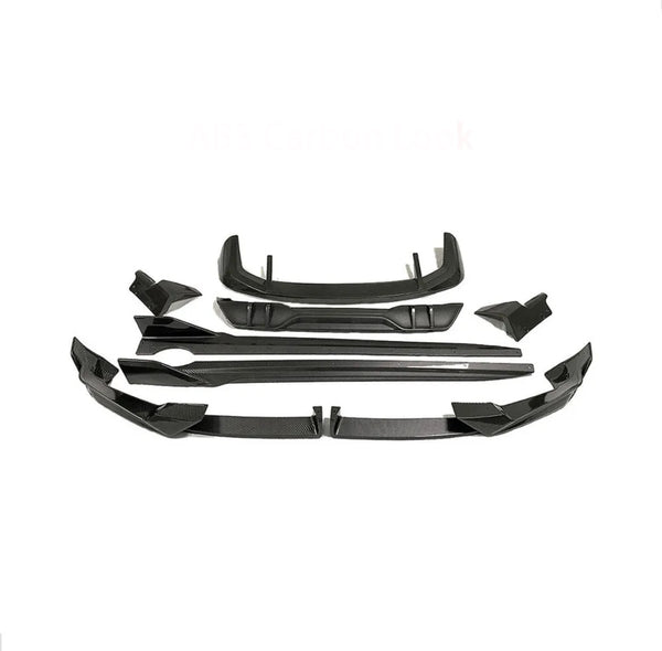 Car body kit parts arranged on a white background, featuring multiple angular black pieces designed for aerodynamic enhancement. Text reads "ABS Carbon Look."