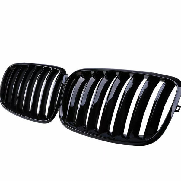 A pair of glossy black car grilles, each with vertical slats, positioned side by side against a white background.