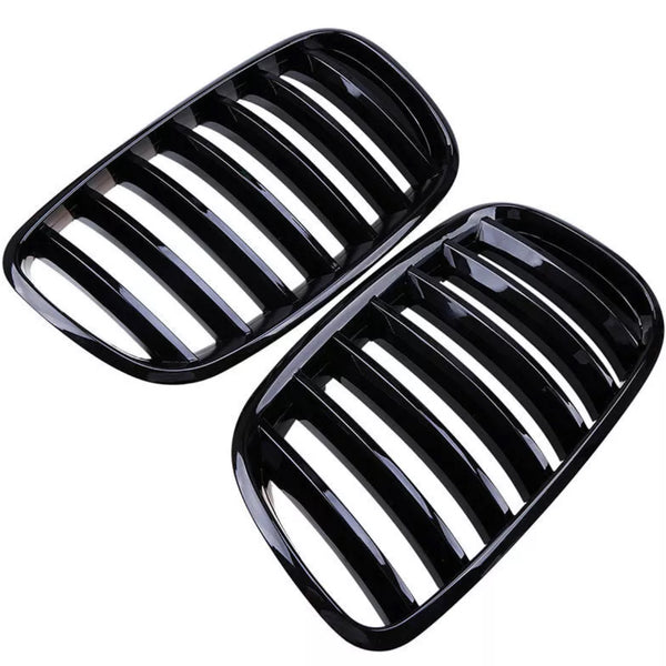 Black kidney-shaped car grilles with multiple vertical slats are placed side by side against a white background, showcasing their sleek, glossy finish.
