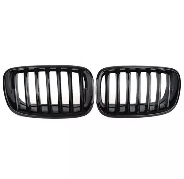 Two black car grilles with vertical slats are displayed side by side against a plain white background, showcasing a sleek automotive accessory design.