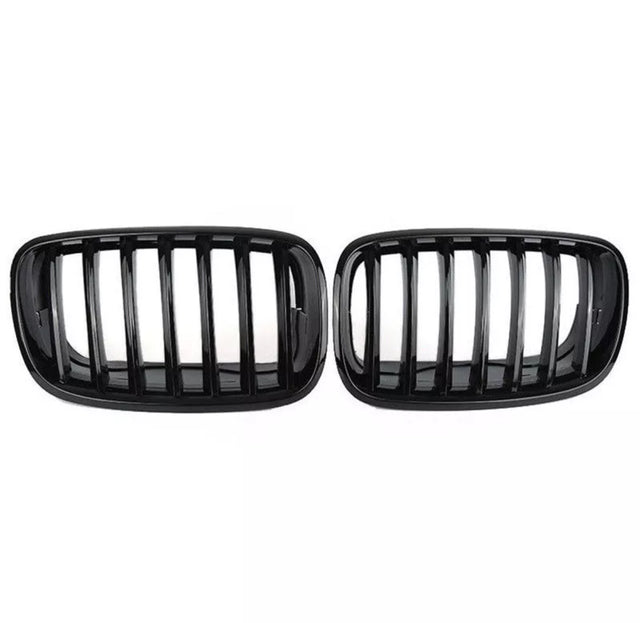 Two black car grilles with vertical slats are displayed side by side against a plain white background, showcasing a sleek automotive accessory design.